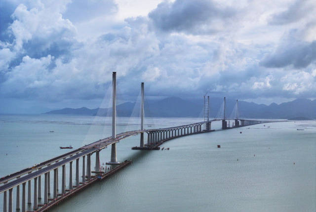 黄茅海跨海通道高栏港大桥（左）和黄茅海大桥（7月16日摄）。黄茅海跨海通道是粤港澳大湾区又一超大型跨海工程，连接珠海市和江门市，线路全长约31公里。跨海段由高栏港大桥和黄茅海大桥两座主桥组成，项目预计2024年年底通车。新华社记者 刘大伟 摄