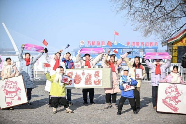 △2月3日，观众在亚冬会火炬传递沿途为火炬手加油。
