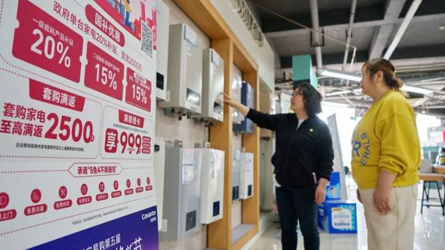 在浙江嘉兴南湖区南溪路一家大型家电商场，工作人员向消费者介绍一款参与政府补贴活动的热水器（2025年4月15日摄）。新华社发（金鹏摄）