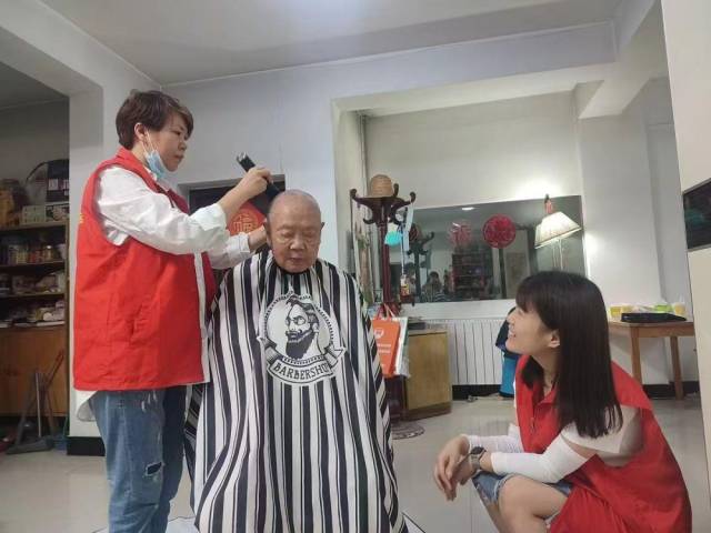 △陕西西安碑林区黄雁社区的工作人员和志愿者上门为留守老人提供剪发服务。