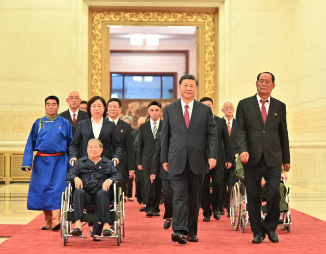 2021年6月，“七一勋章”颁授仪式隆重举行。习近平总书记同“七一勋章”获得者一同步入人民大会堂金色大厅。新华社记者 李涛 摄