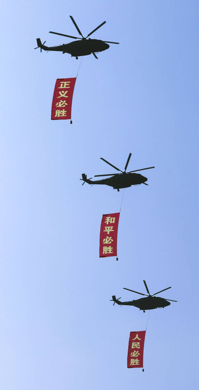 2025年9月3日，纪念中国人民抗日战争暨世界反法西斯战争胜利80周年大会在北京隆重举行。这是空中护旗梯队通过天安门广场，3架直-8L运输直升机分别悬挂“正义必胜”“和平必胜”“人民必胜”条幅。新华社记者 李钢 摄