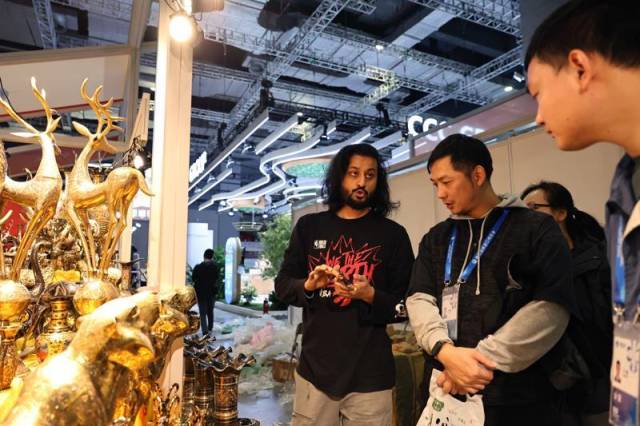 △一名巴基斯坦展商(左)在布置进博会展位时与工作人员交流。 △一名巴基斯坦展商(左)在布置进博会展位时与工作人员交流。