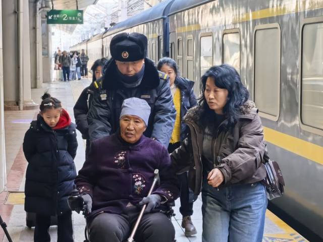 朱春生（左三）正在帮助行动不便的旅客出站。新华社记者 叶昊鸣 摄