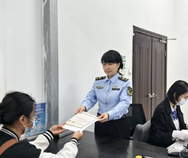 2026年2月6日，广州白云区市场监管局副局长孔丽雅（中）在帮助市民办理营业执照。（受访者供图）