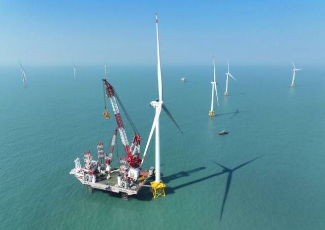 这是2026年1月13日在福建海域拍摄的20兆瓦海上风电机组和“大桥海风”号2000吨自升式海上风电安装平台（无人机照片）。新华社记者 林善传 摄
