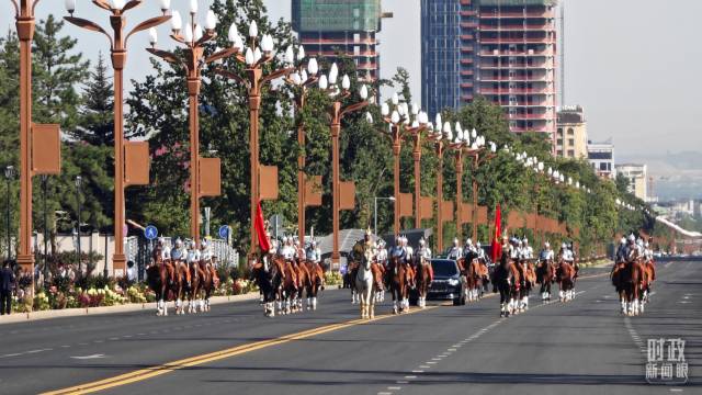 △在骑兵马队护卫下，习近平主席乘车前往和谐宫广场。（总台央视记者韩锐拍摄）