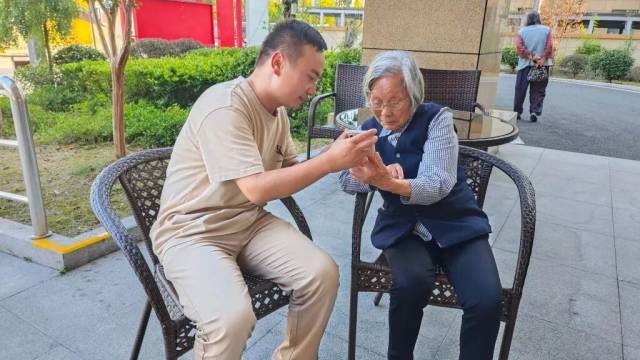 在浙江缙云县一家养老机构，青年志愿者在教老人使用智能手机。新华社记者 唐弢 摄