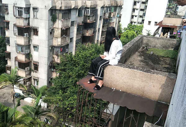7月10日8时许 西区长洲一小区 有一名年轻女孩 坐在楼顶阳台 8时21分