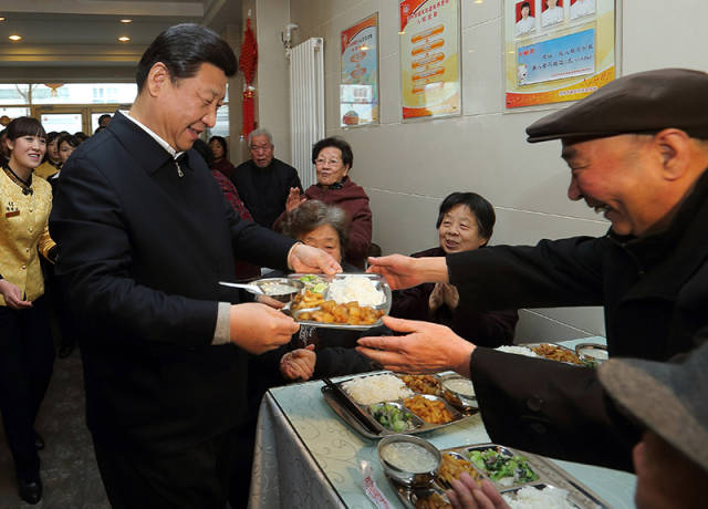 2013年2月4日，习近平总书记来到甘肃兰州一家养老餐厅，端上一盘热气腾腾的饭菜，送到一位老人面前。